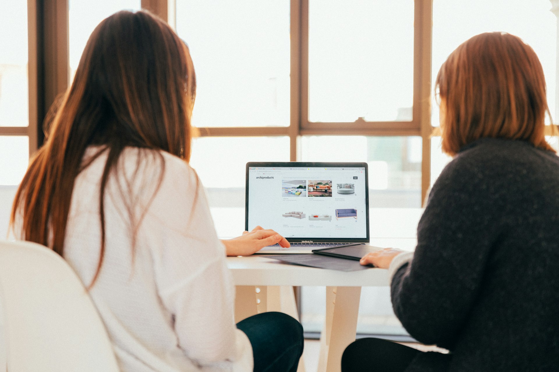 Une femme aide une autre à créer son site web/ecommerce avec le support Odoo